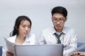 Two young Asian business people working with laptop together in modern office. Team work business concept. Selective focus and sha Royalty Free Stock Photo