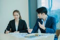 Two young Asian businessmen working together at the Financial Graph computer office. Share ideas, discuss and train business plans