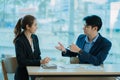 Two young Asian businessmen working together at the Financial Graph computer office. Share ideas, discuss and train business plans