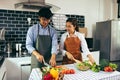 Two young asian couples are helping each other and enjoying cooking in the kitchen Royalty Free Stock Photo