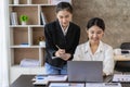 Two young Asian female accountants discuss working