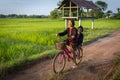 Two young asian girls dressed up according to local traditions and Ride a bicycle with fun expressions and smiles, on the road Royalty Free Stock Photo