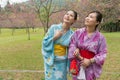 Two young Asian girls stand walking together Royalty Free Stock Photo