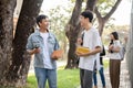 Two young Asian male best friends are enjoying talking while walking on a footpath on their campus Royalty Free Stock Photo