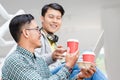 Two young Asian men using a laptop while relaxing during break Royalty Free Stock Photo