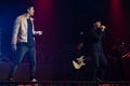 Two young Asian pop rock singers and band are performing with full spectrum of light and sound at the concert Royalty Free Stock Photo