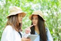 Two young Asian teenage girls are best friends. Another friend holds a tablet in his hand and looks at his walking route. hiking Royalty Free Stock Photo