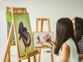 Two young asian woman artist dawning while useing ideas to think and create the best artwork