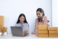 Two young Asian women chat with bright smiles to customers who shop online via laptop and confirm the order to close the deal