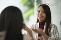 Two young Asian women friends talking at a coffee shop. Royalty Free Stock Photo