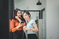 Two young asian women listening to music on couch in living room at home. Royalty Free Stock Photo