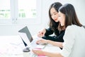 Two young asian women in office working and happy together on desktop Royalty Free Stock Photo