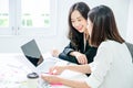 Two young asian women in office working and happy together on desktop Royalty Free Stock Photo