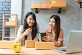 Two young Asian women startup small business entrepreneur SME distribution warehouse with parcel mail box. small owner home