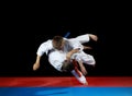 Two young athletes in the sharp drop perform judo throw