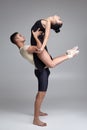 Two athletic modern ballet dancers are posing against a gray studio background. Royalty Free Stock Photo