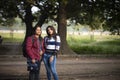 Two young Indian sisters walking in a field in winter afternoon. Royalty Free Stock Photo