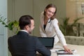 Two young and attractive colleagues man and woman flirting at office. Young woman sitting on the table and sexually Royalty Free Stock Photo