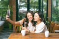 Two young and attractive females taking selfie while sitting in the cafe Royalty Free Stock Photo