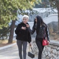 Two young attractive women walking along park