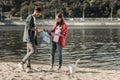 Two young beaming students standing near the river while cleaning the sand Royalty Free Stock Photo