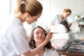 Two young beautician students working during make up classes