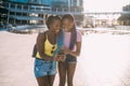 Two young beautiful black sisters outdoor using smartphone Royalty Free Stock Photo
