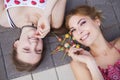 Two young beautiful blonde hipster girls on summer day having fun in european city. Eating lollipops. Copy space Royalty Free Stock Photo