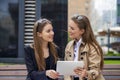 Two young beautiful business women sitting on a bench Royalty Free Stock Photo