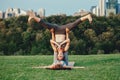 Two Caucasian women doing yoga stretching workout in park outdoors at sunset Royalty Free Stock Photo