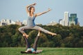 Two Caucasian women doing yoga stretching workout in park outdoors at sunset Royalty Free Stock Photo