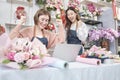 Two young beautiful female florist partners happily work as a florist. Royalty Free Stock Photo