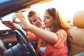 Two young beautiful girls are doing selfie in a convertible Royalty Free Stock Photo