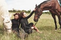 Two young beautiful girls in gear for riding near their horses. They love animals Royalty Free Stock Photo