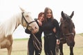 Two young beautiful girls in gear for riding near their horses. They love animals Royalty Free Stock Photo