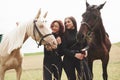 Two young beautiful girls in gear for riding near their horses. They love animals Royalty Free Stock Photo