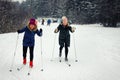 Two young beautiful girls go skiing in winter on a ski slope Royalty Free Stock Photo