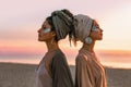 Two young beautiful girls in turban on the beach at sunset Royalty Free Stock Photo
