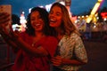 Two young beautiful happy enthusiastic girls taking selfie on phone