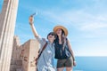 Two young beautiful happy woman female travel girlfriends doing