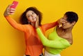 Two young beautiful hipster girls in colorful clothes taking a selfie Royalty Free Stock Photo