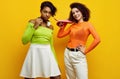 Two young beautiful hipster girls in trendy colorful summer clothes Royalty Free Stock Photo