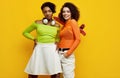 Two young beautiful hipster girls in trendy colorful summer clothes Royalty Free Stock Photo