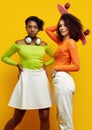 Two young beautiful hipster girls in trendy colorful summer clothes Royalty Free Stock Photo