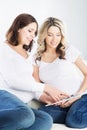 Two young beautiful pregnant women watching ultrasound scans
