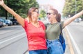 Two young beautiful  smiling girls in a summer day whit colored t-shirt clothes and jeans Royalty Free Stock Photo