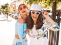 Two young beautiful smiling hipster girls in trendy summer clothes Royalty Free Stock Photo