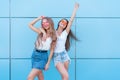 Two young beautiful smiling hipster girls in trendy summer colorful neon sunglasses. carefree women posing near Royalty Free Stock Photo