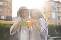 Two young beautiful smiling woman in summer clothes are having fun in city and drinking fresh cocktail Royalty Free Stock Photo