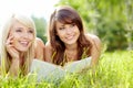 Two young beautiful smiling women reading book Royalty Free Stock Photo
